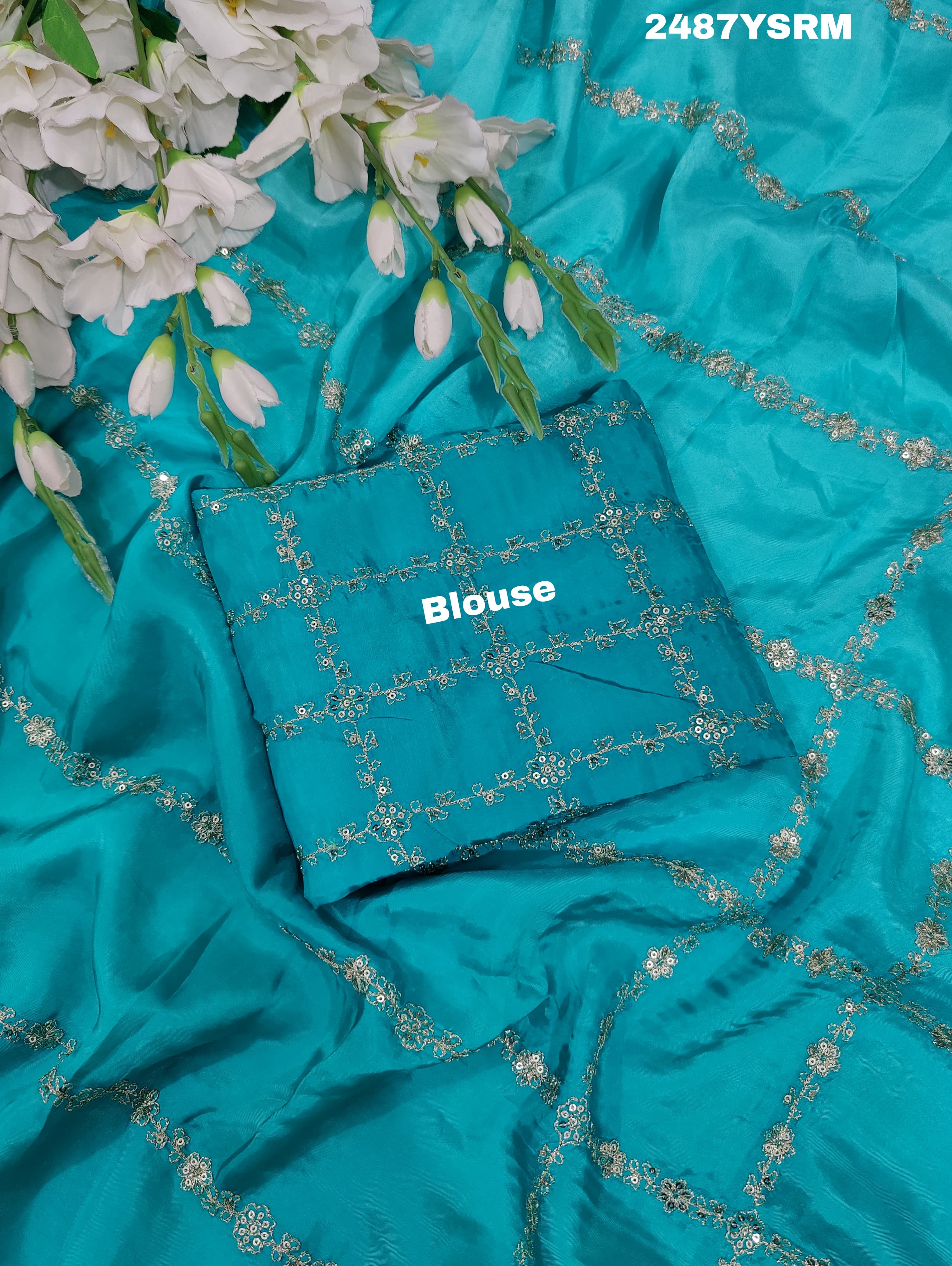 A sea green color saree with geometric pattern and pittan work