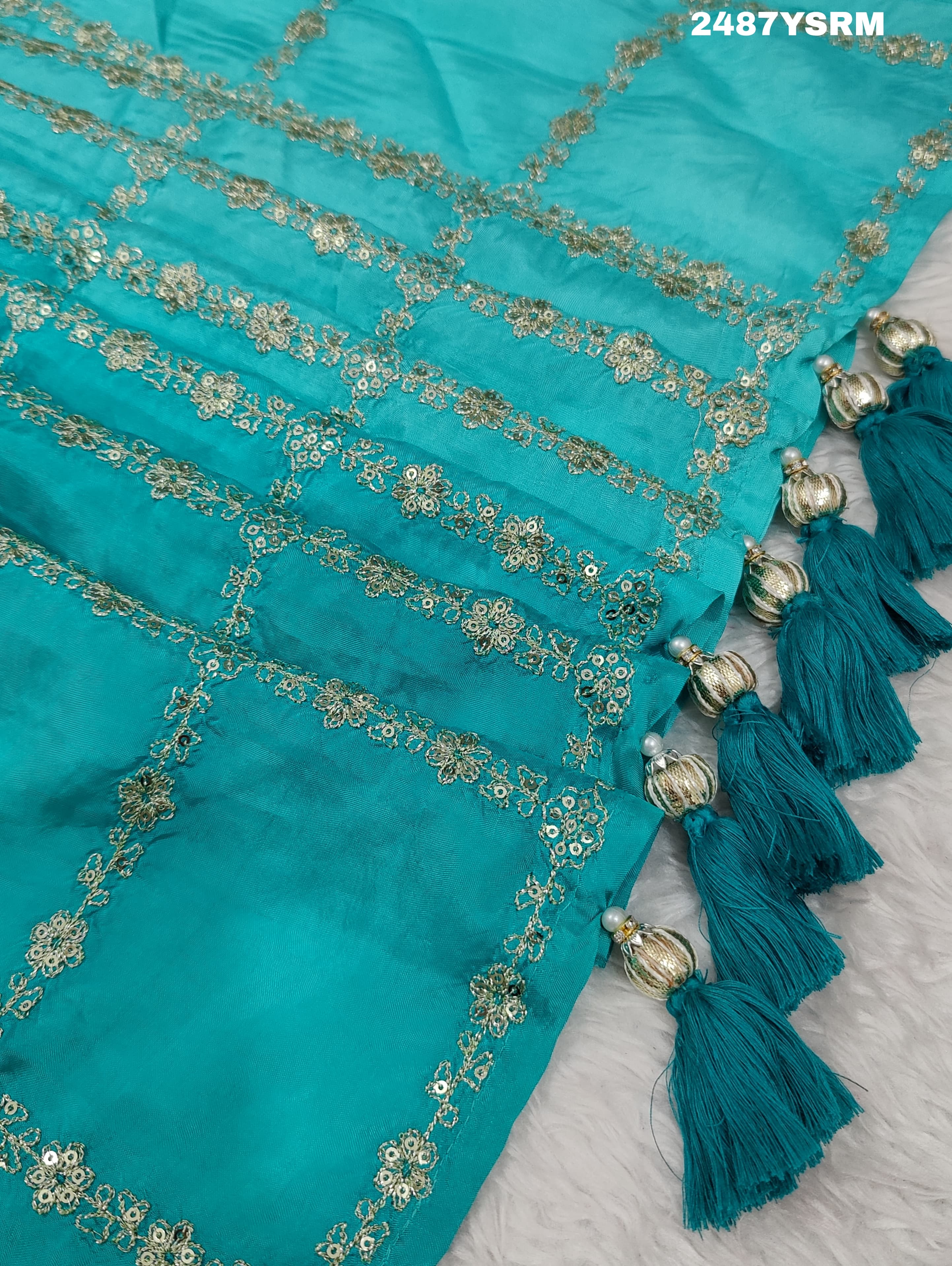 A sea green color saree with geometric pattern and pittan work