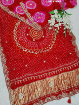 A red Gaji silk saree with Bandhani style embellishments and Gotapatti work