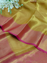 A Banarasi style tissue silk saree with zari border work yellow and pink color