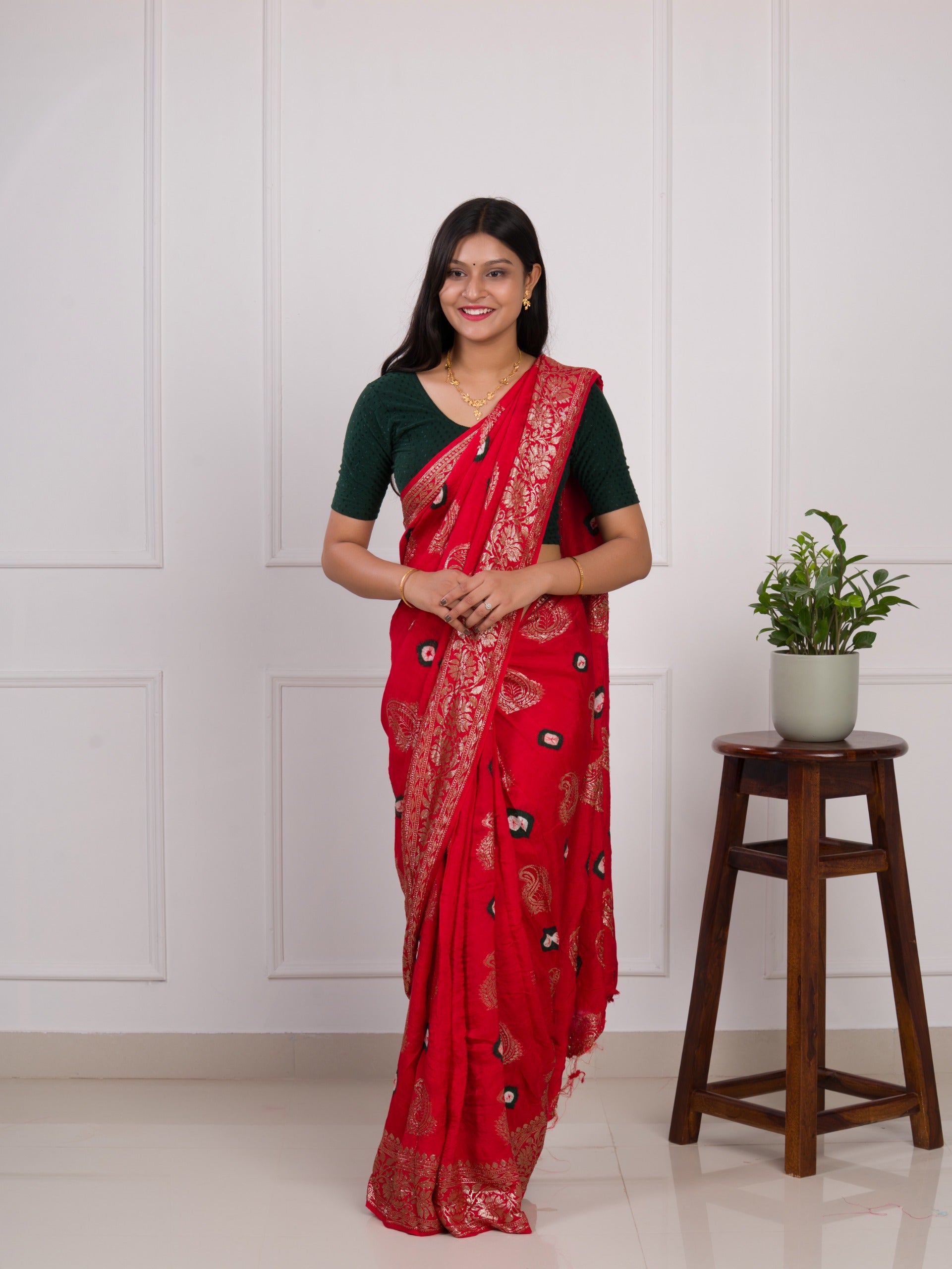 A red saree with green patterns withDola Silk Bandhani Zari Weaving Work