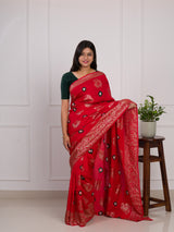 A red saree with green patterns withDola Silk Bandhani Zari Weaving Work