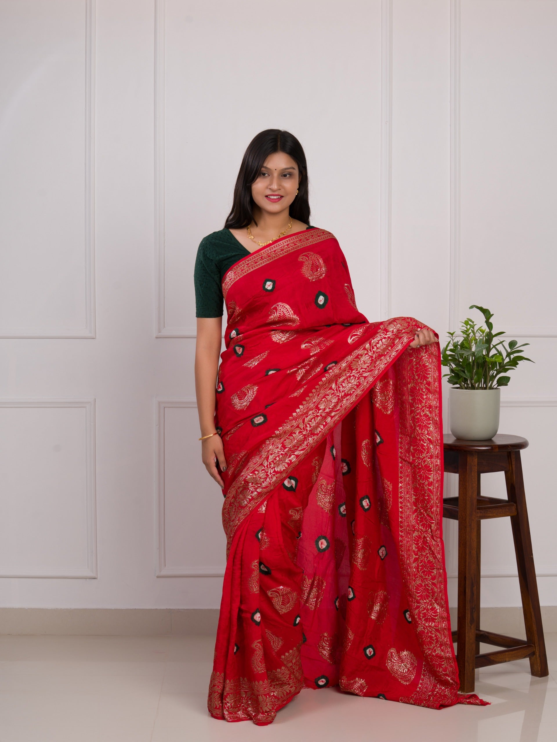 A red saree with green patterns withDola Silk Bandhani Zari Weaving Work