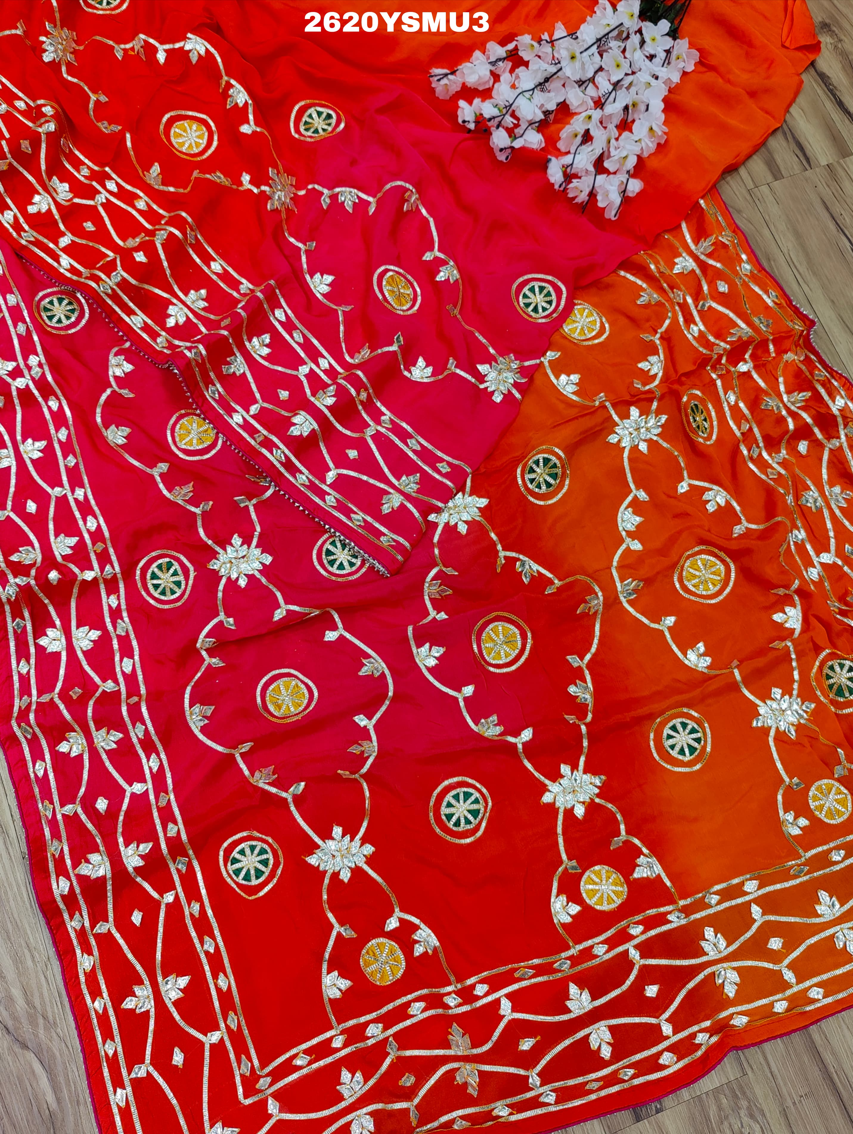 Red and orange saree with white floral patternsBollywood Style with Gotapatti Work