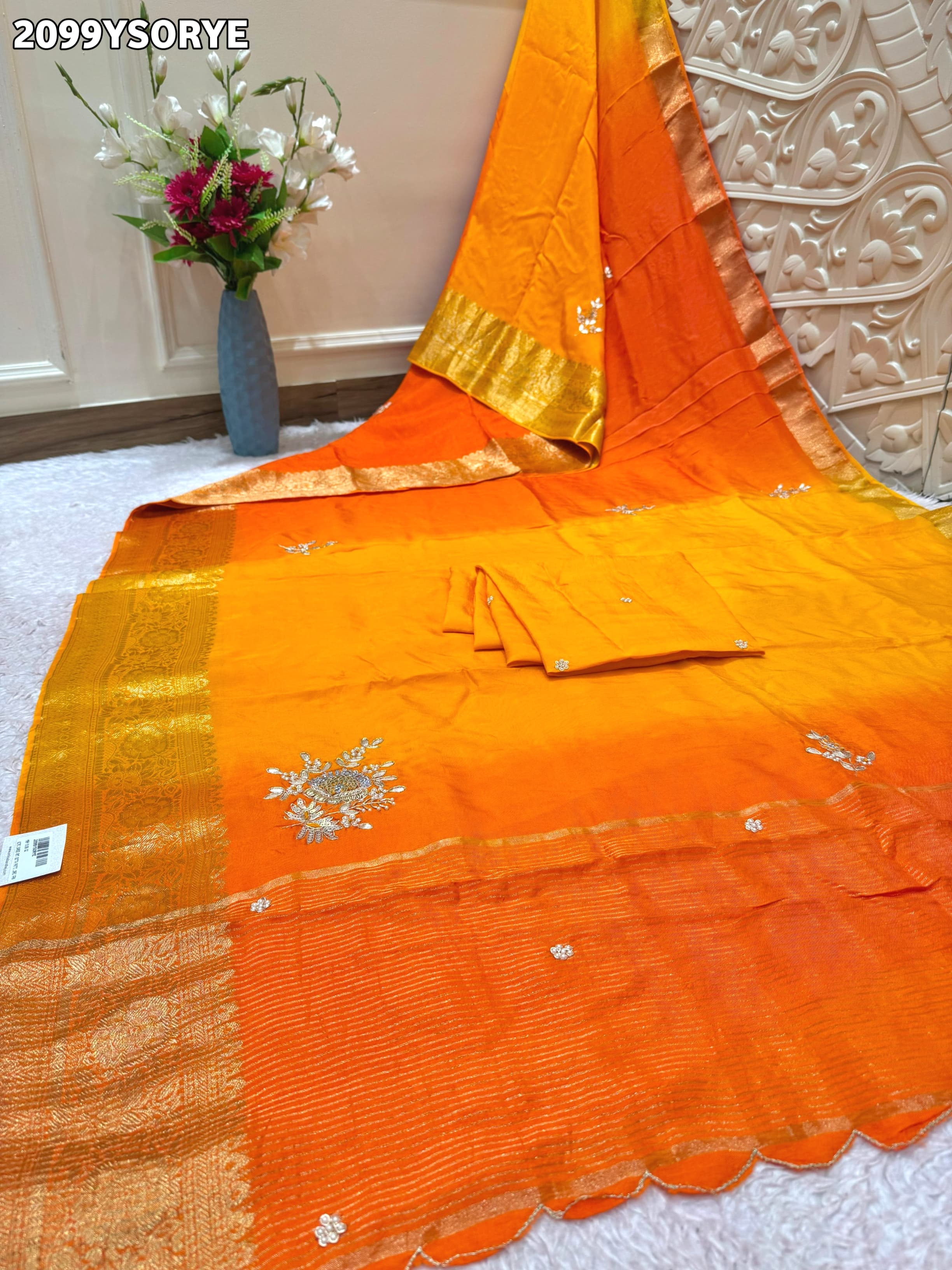 By Orange saree with gold border and floral embroidery