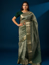 A green and gold Banarasi style saree with zari border.