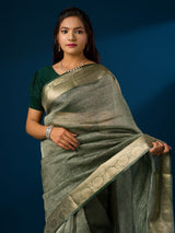 A green and gold Banarasi style saree with zari border.