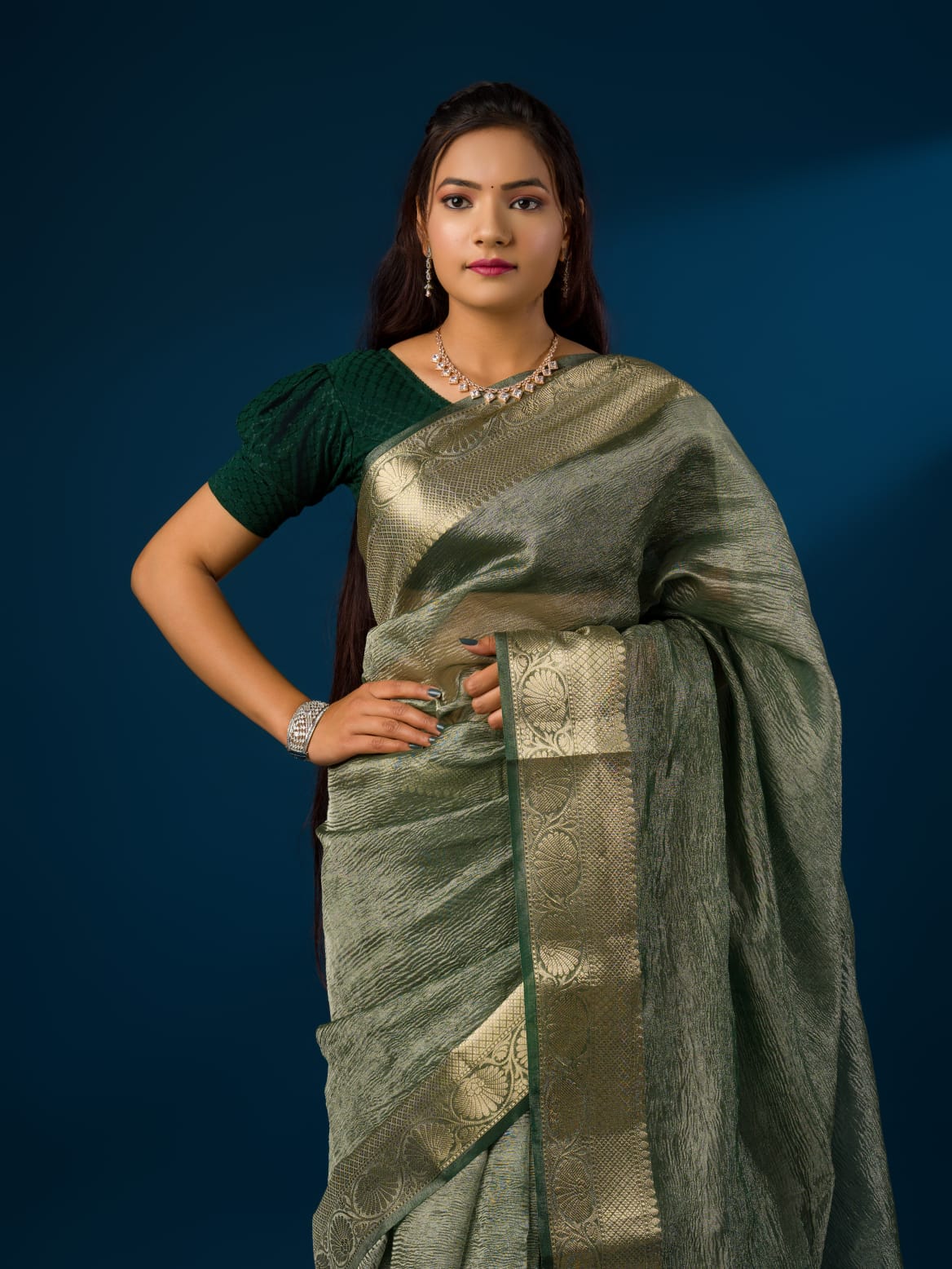 A green and gold Banarasi style saree with zari border.