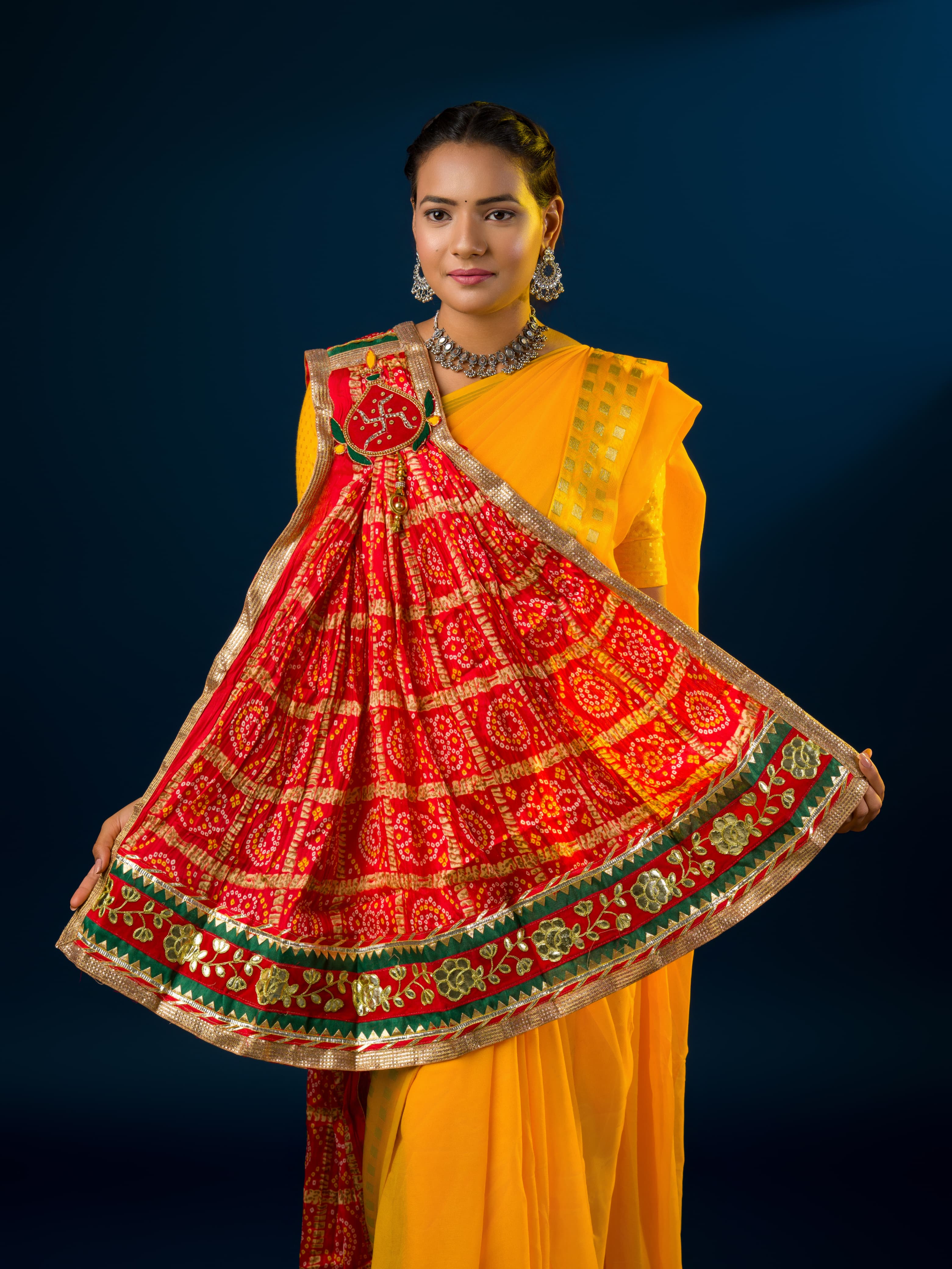 Atraditional Rajasthani Marwadi chunri pila with red and yellow colors, featuring heavy embellishments and a yellow border.