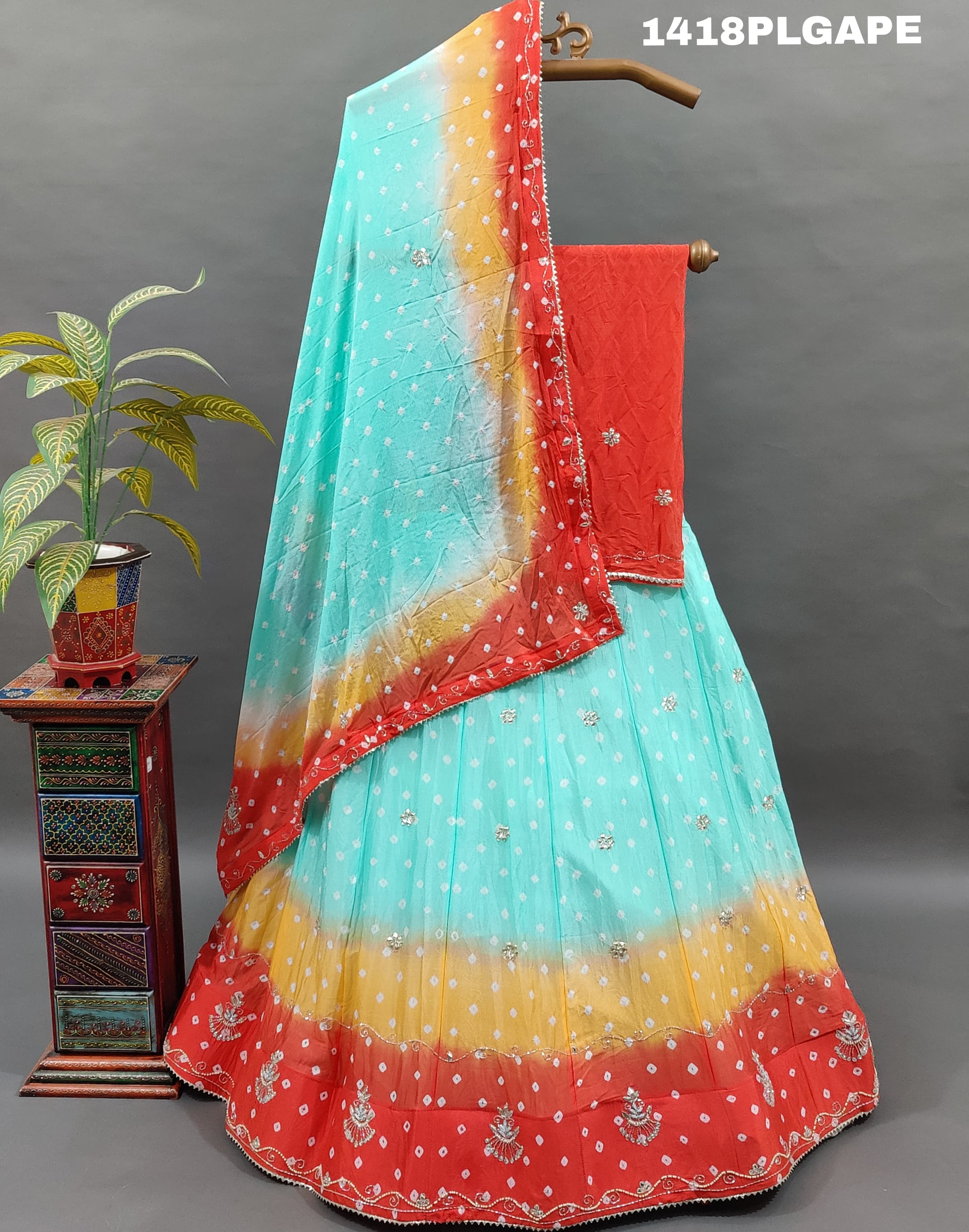 A Lehenga with a multi-color bandhani pattern and cutdana