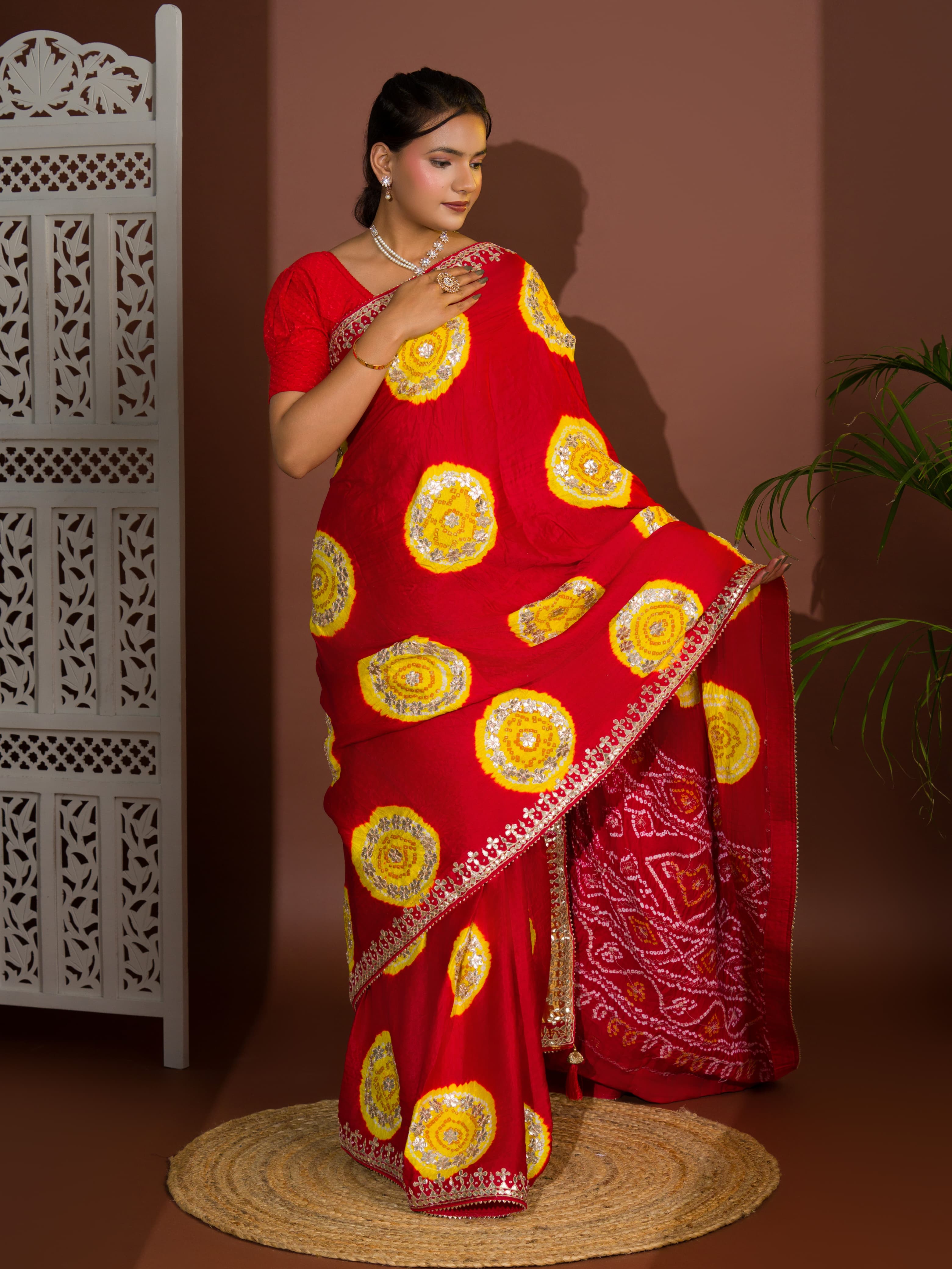A red saree with bandhej style and gotapatti work in red and yellow colour