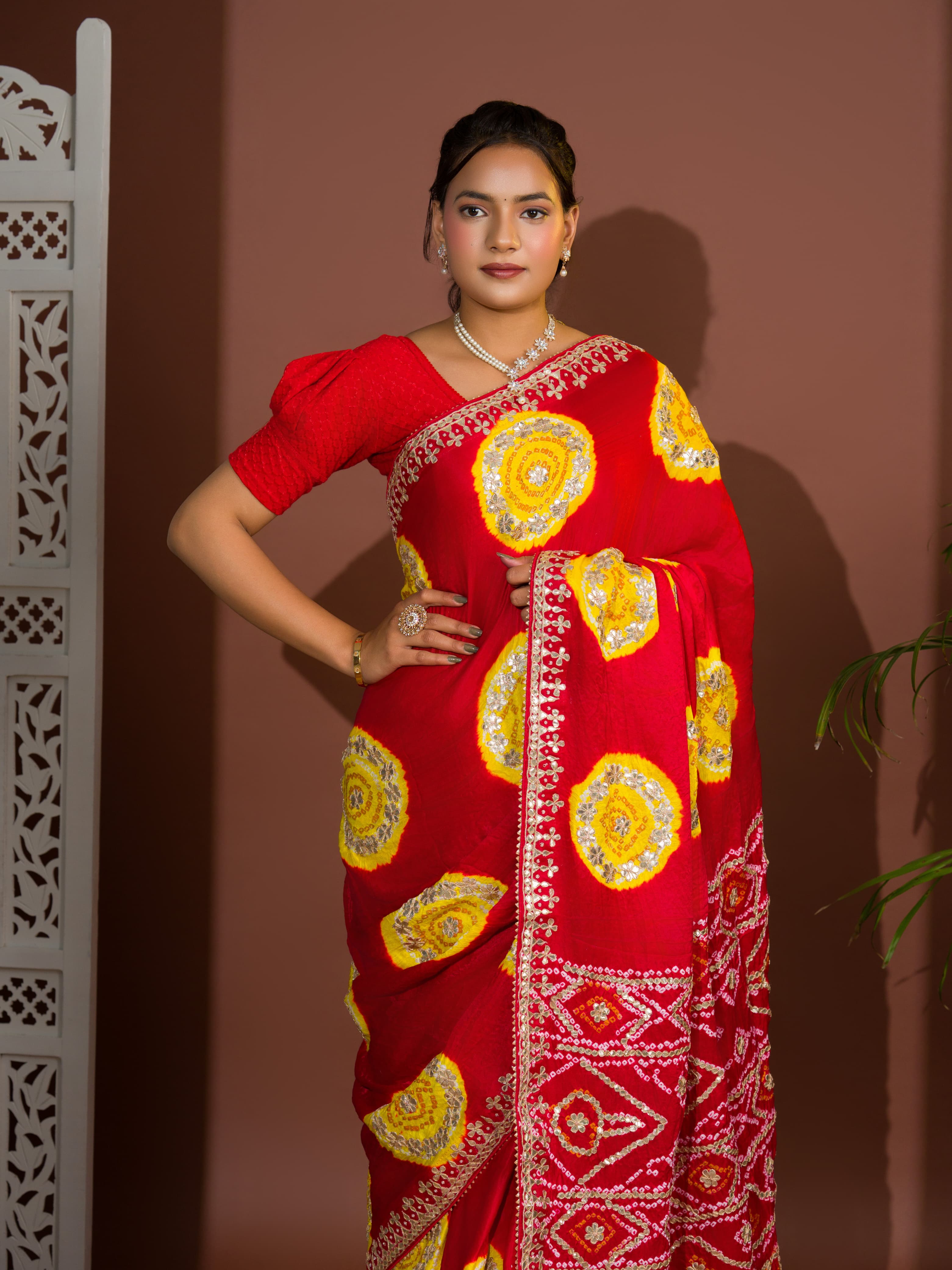 A red saree with bandhej style and gotapatti work in red and yellow colour