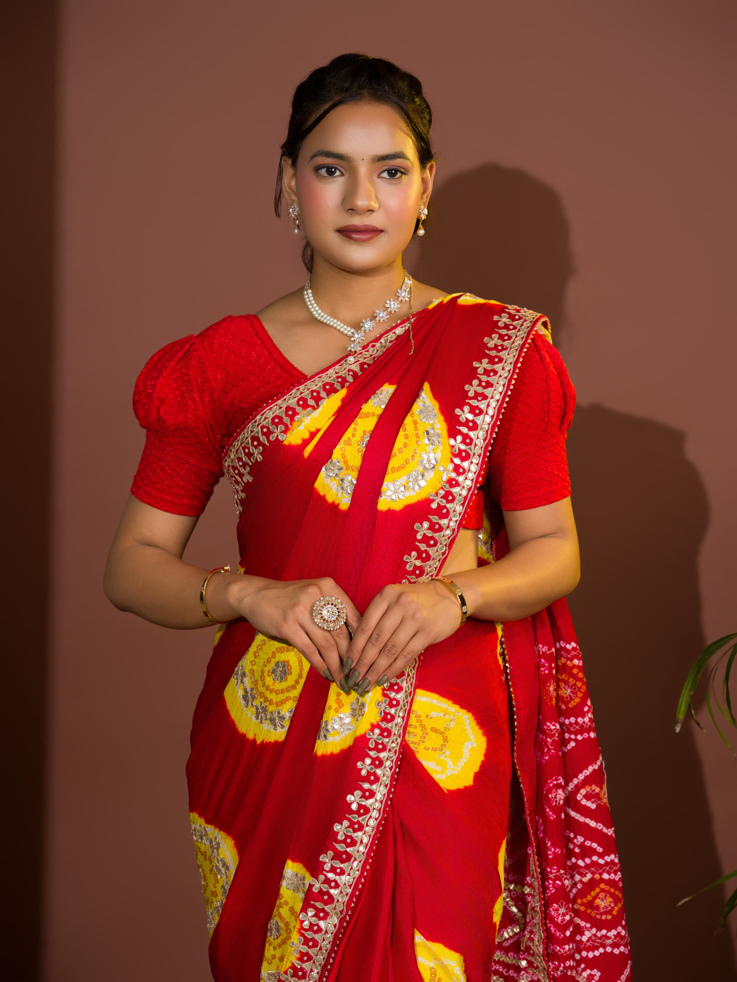 A red saree with bandhej style and gotapatti work in red and yellow colour