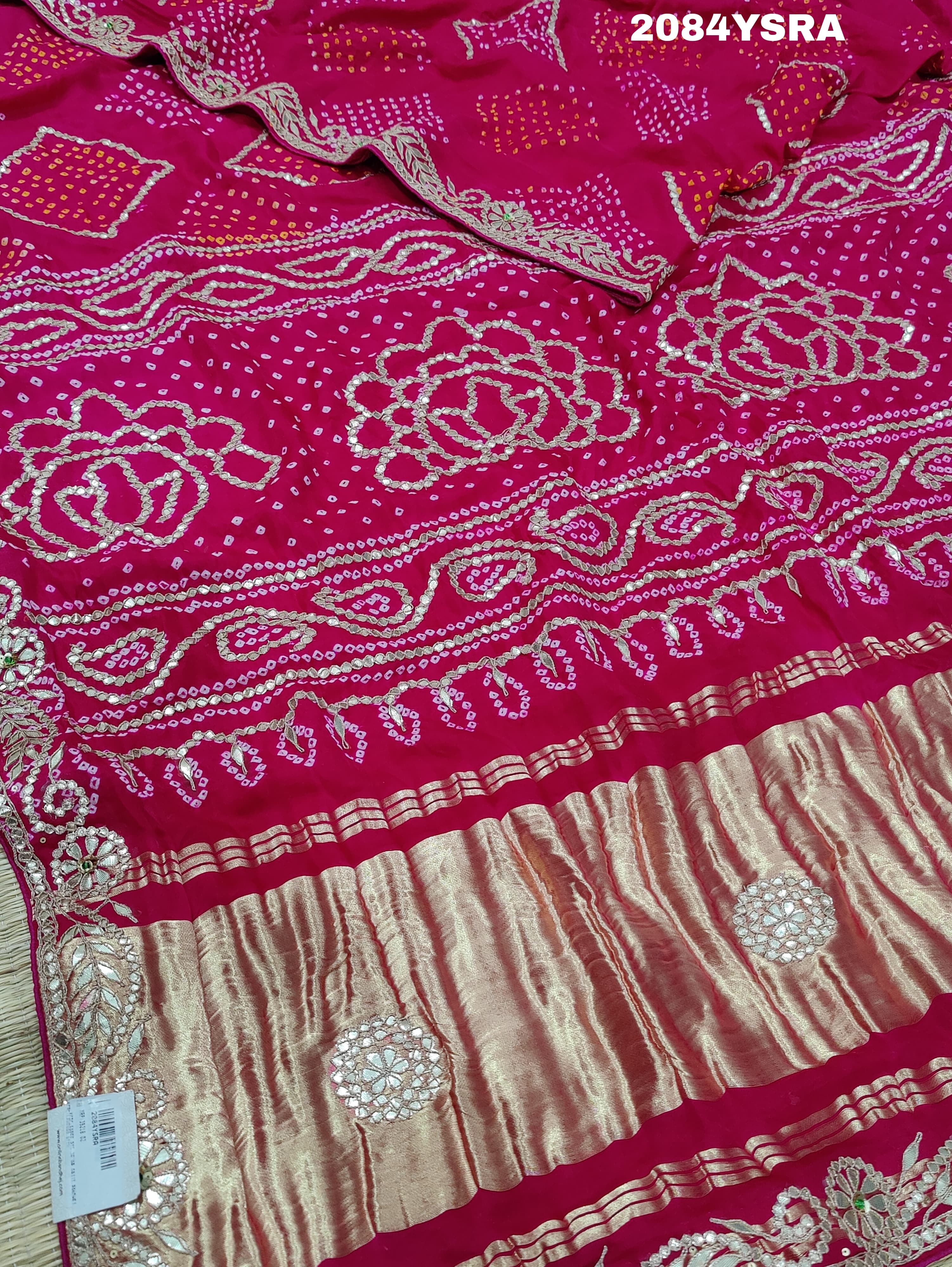 A pink and red bandhani style saree with gotapatti work