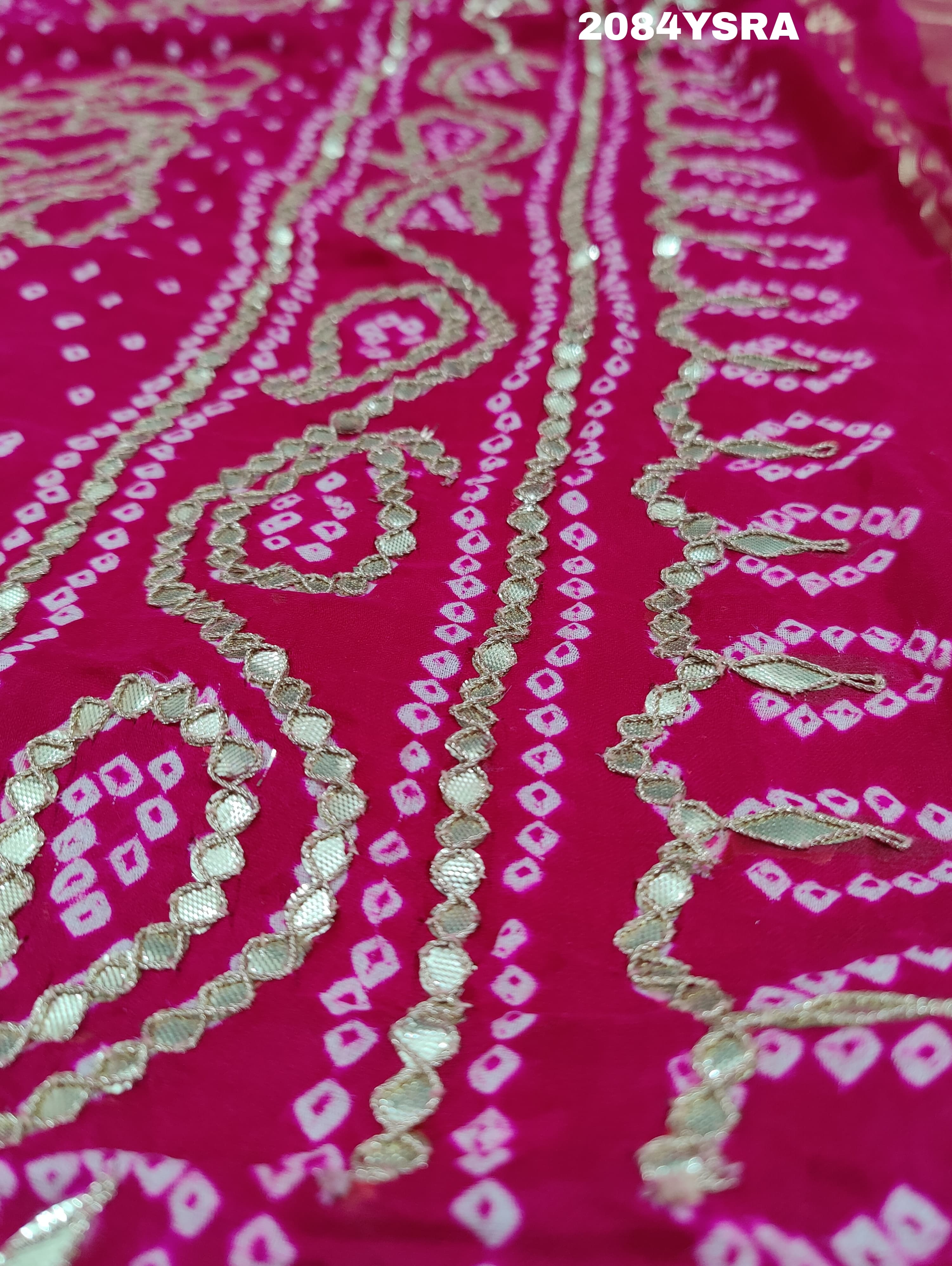 A pink and red bandhani style saree with gotapatti work