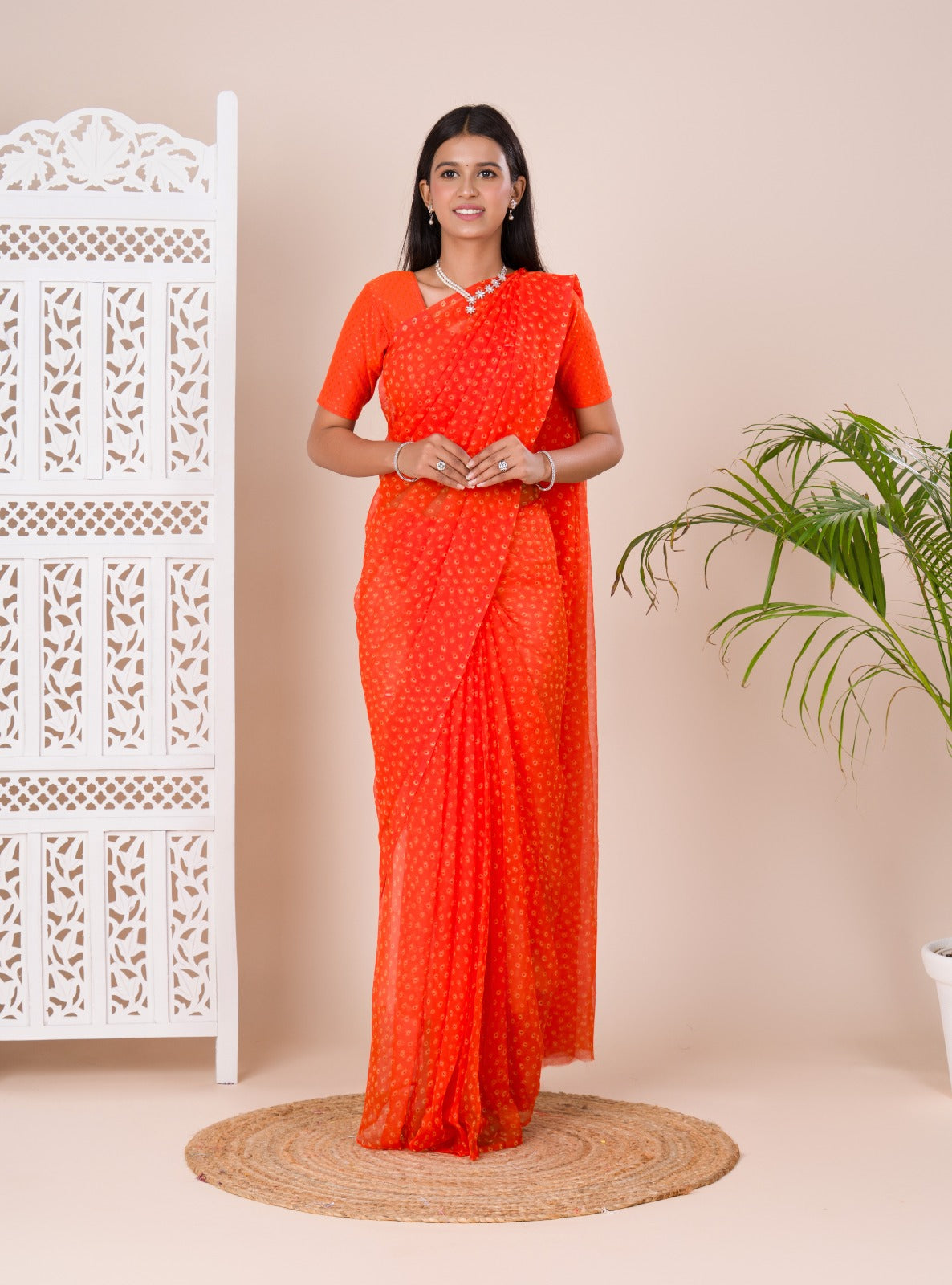 an orange chiffon saree with a bandhani pattern