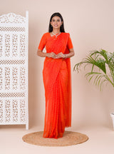 an orange chiffon saree with a bandhani pattern