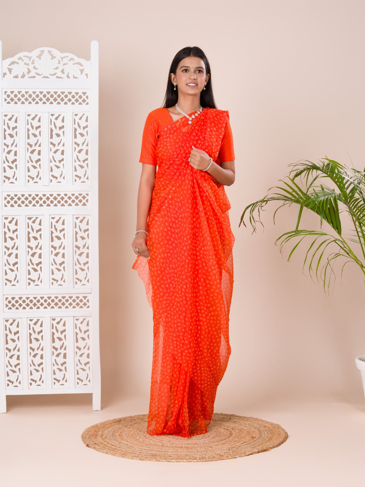 an orange chiffon saree with a bandhani pattern