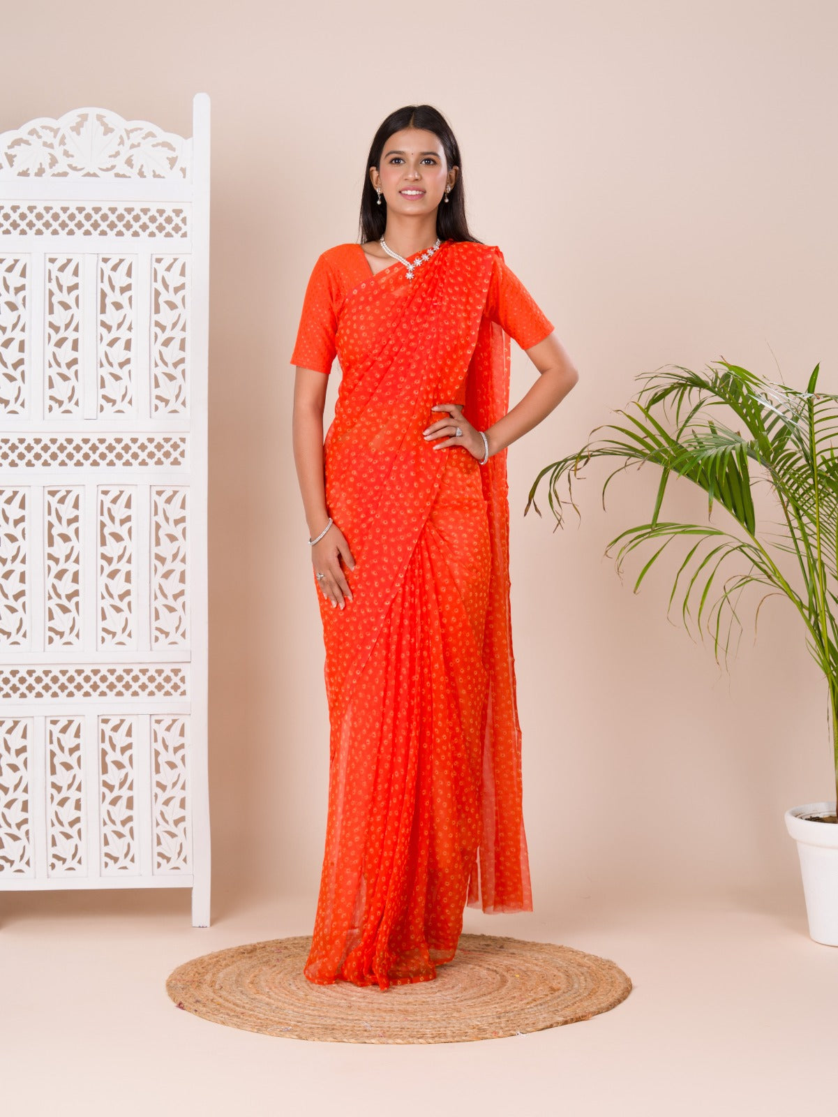 an orange chiffon saree with a bandhani pattern