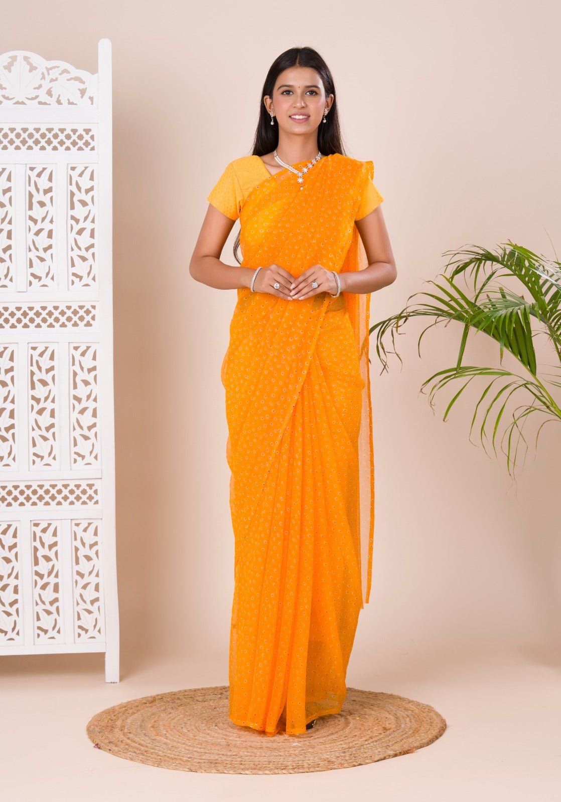 A yellow chiffon saree with a bandhani pattern