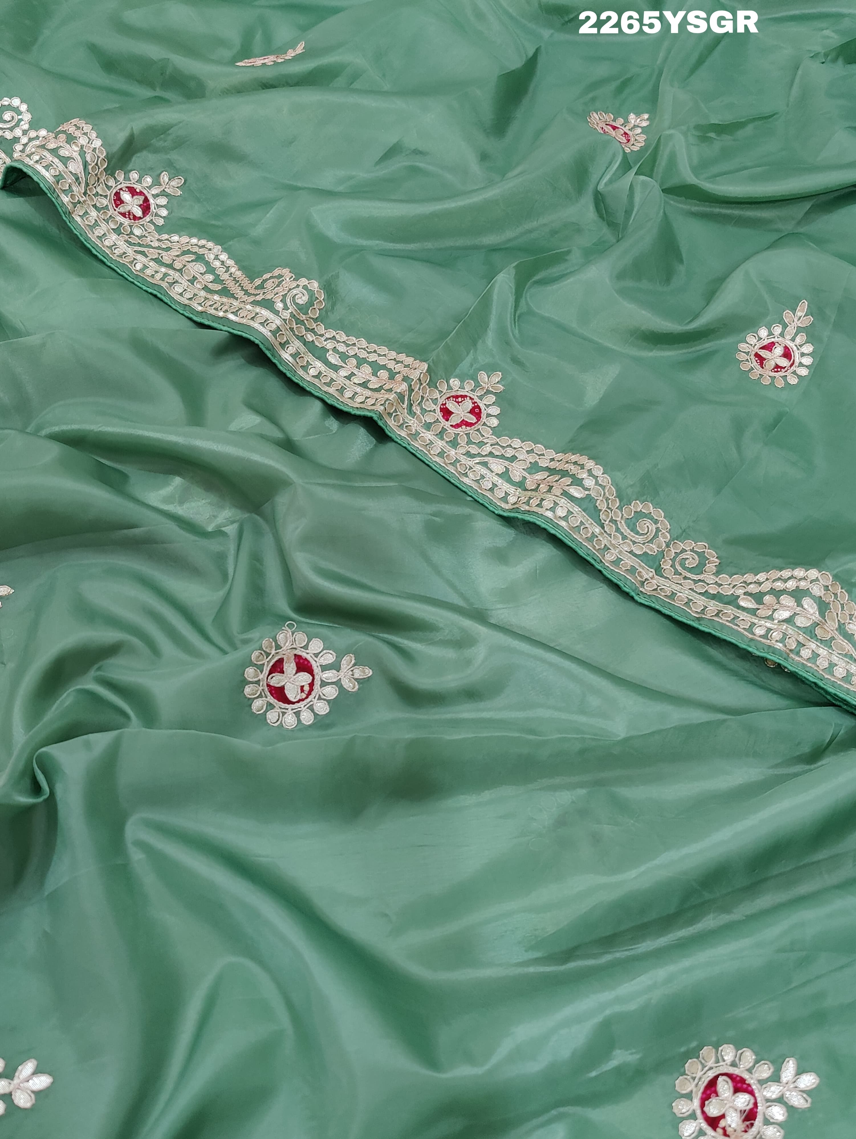 A green saree with tissue silk texture and Gotapatti work embroidery.