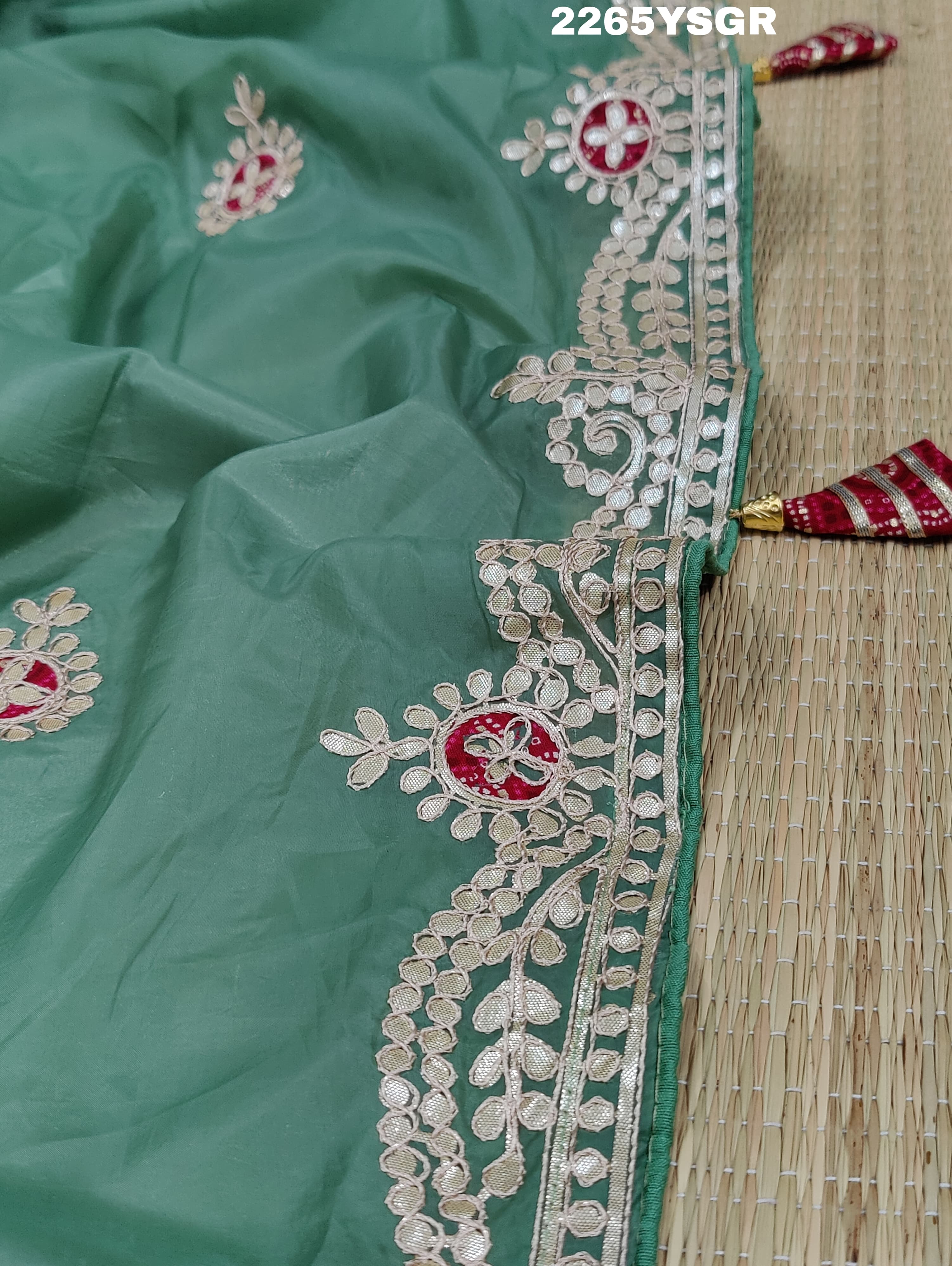 A green saree with tissue silk texture and Gotapatti work embroidery.