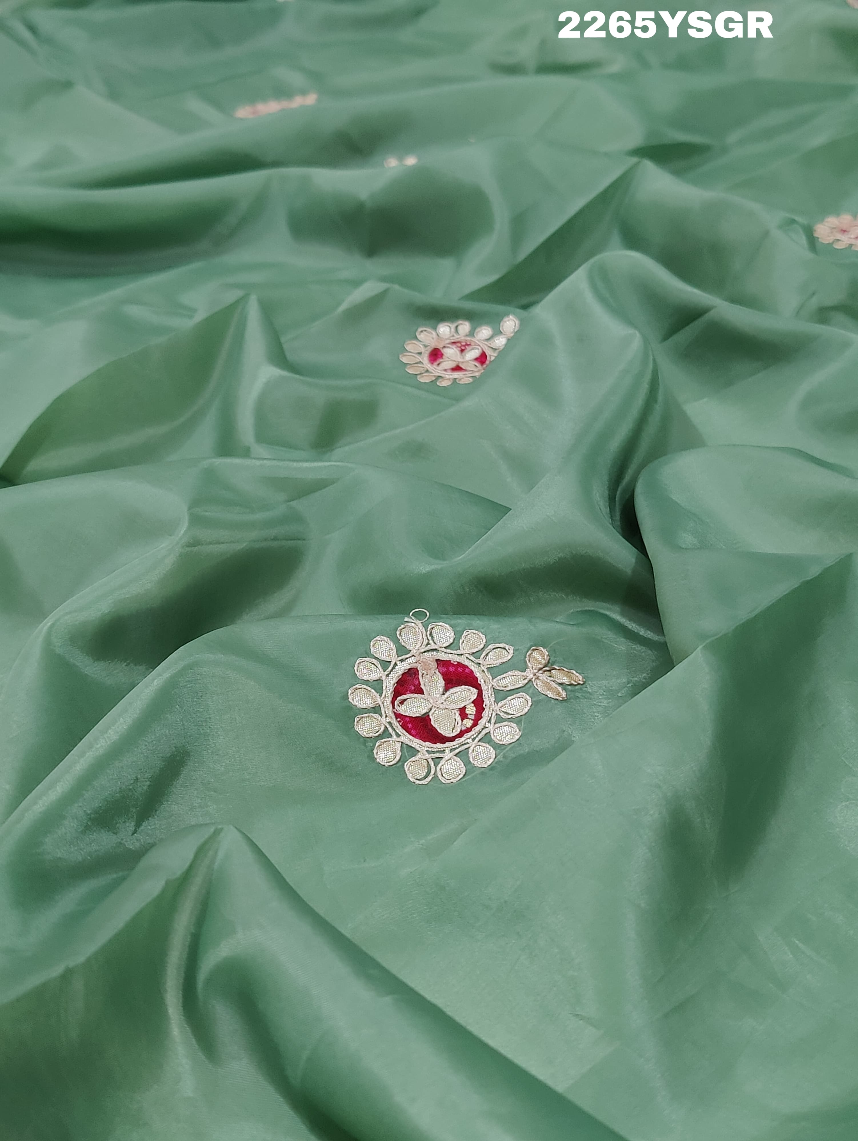 A green saree with tissue silk texture and Gotapatti work embroidery.