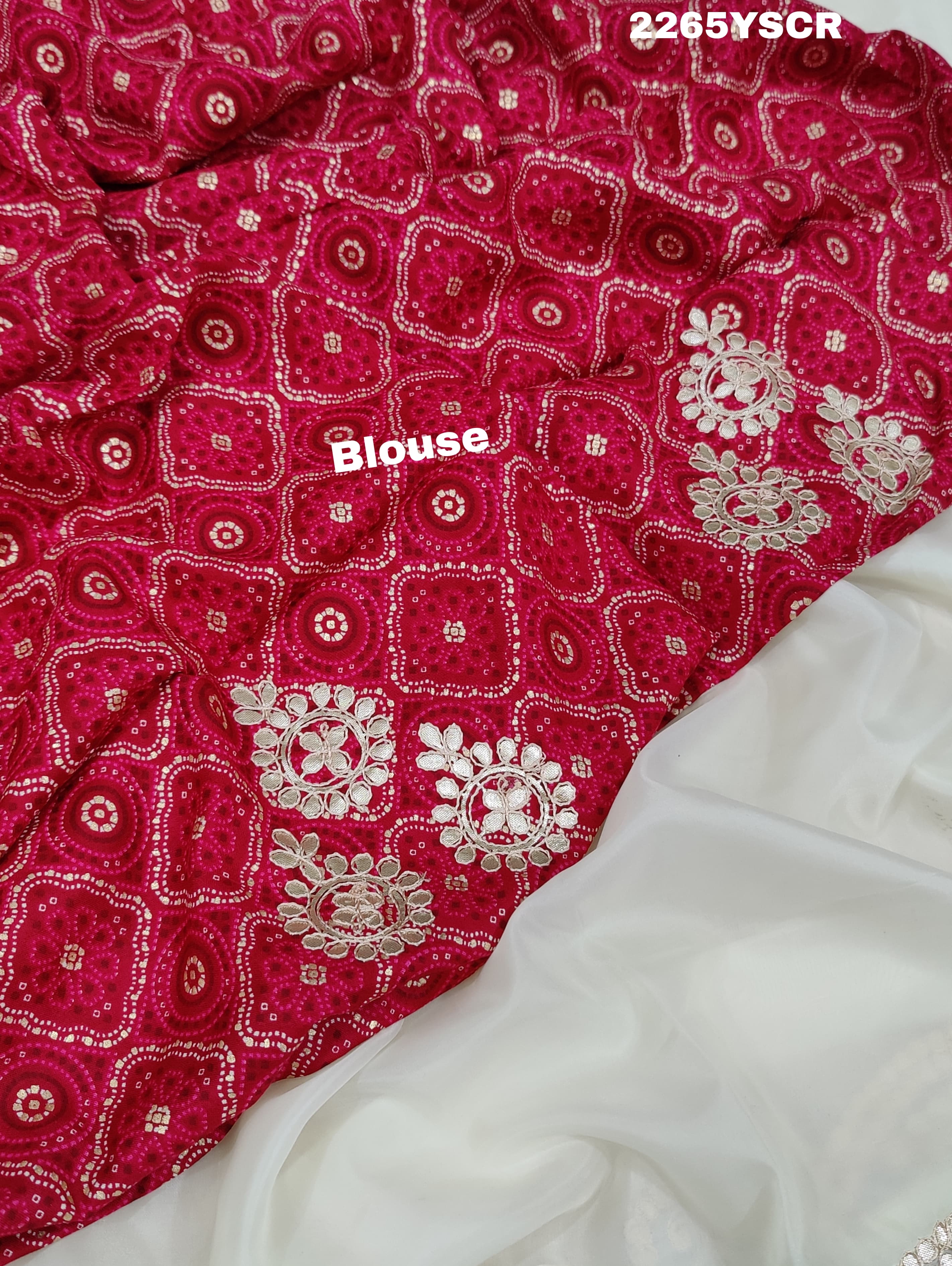 A cream-colored tissue silk saree with Bollywood-style embellishments and gotapatti work, including floral patterns and traditional border designs.