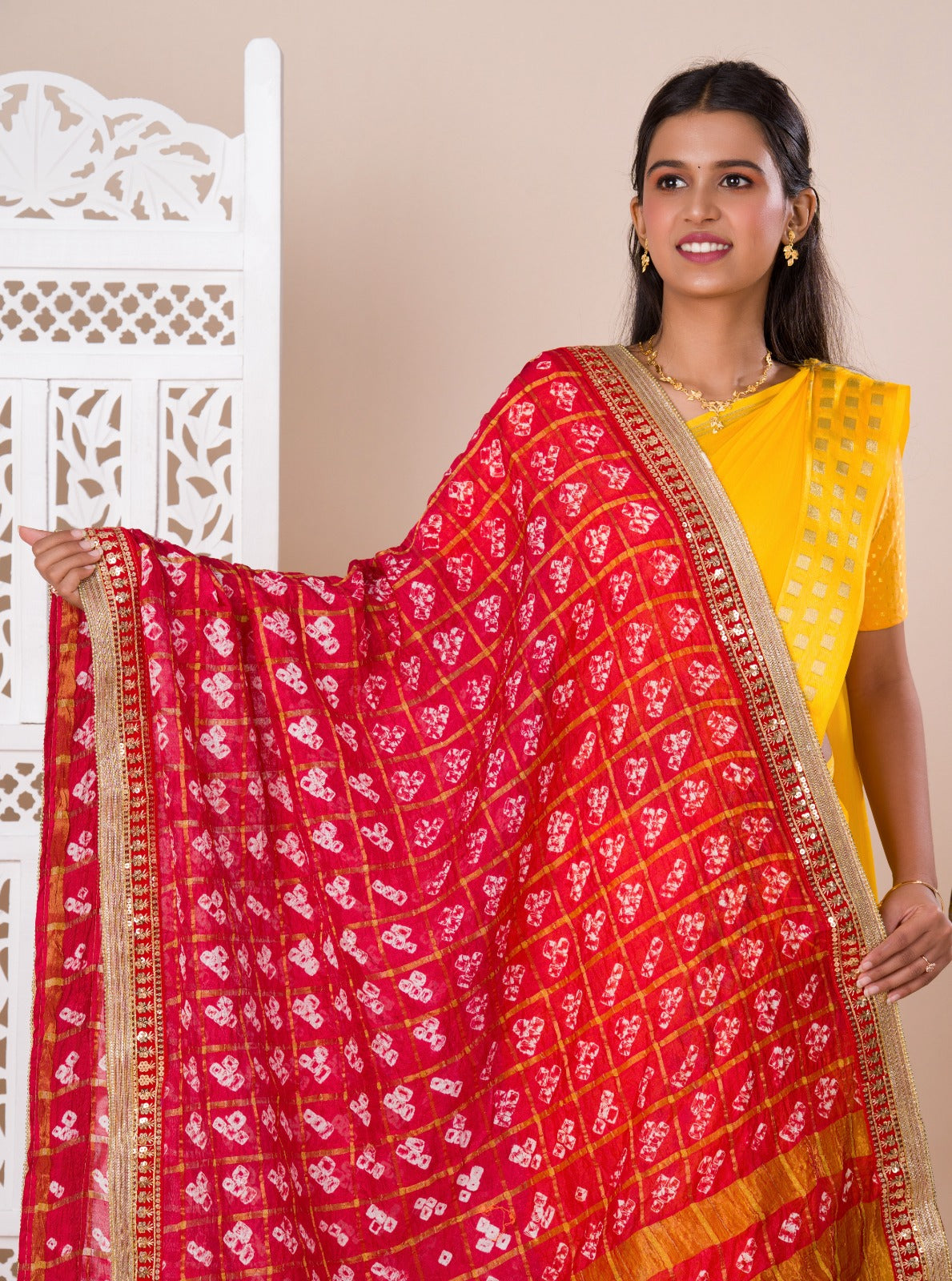 A traditional Rajasthani Bandhani Chunri Piliya Dupatta in red and yellow with a floral pattern