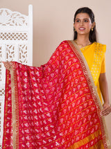 A traditional Rajasthani Bandhani Chunri Piliya Dupatta in red and yellow with a floral pattern