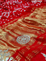 A red saree with white bandhani (dot) pattern and gotapatti border,