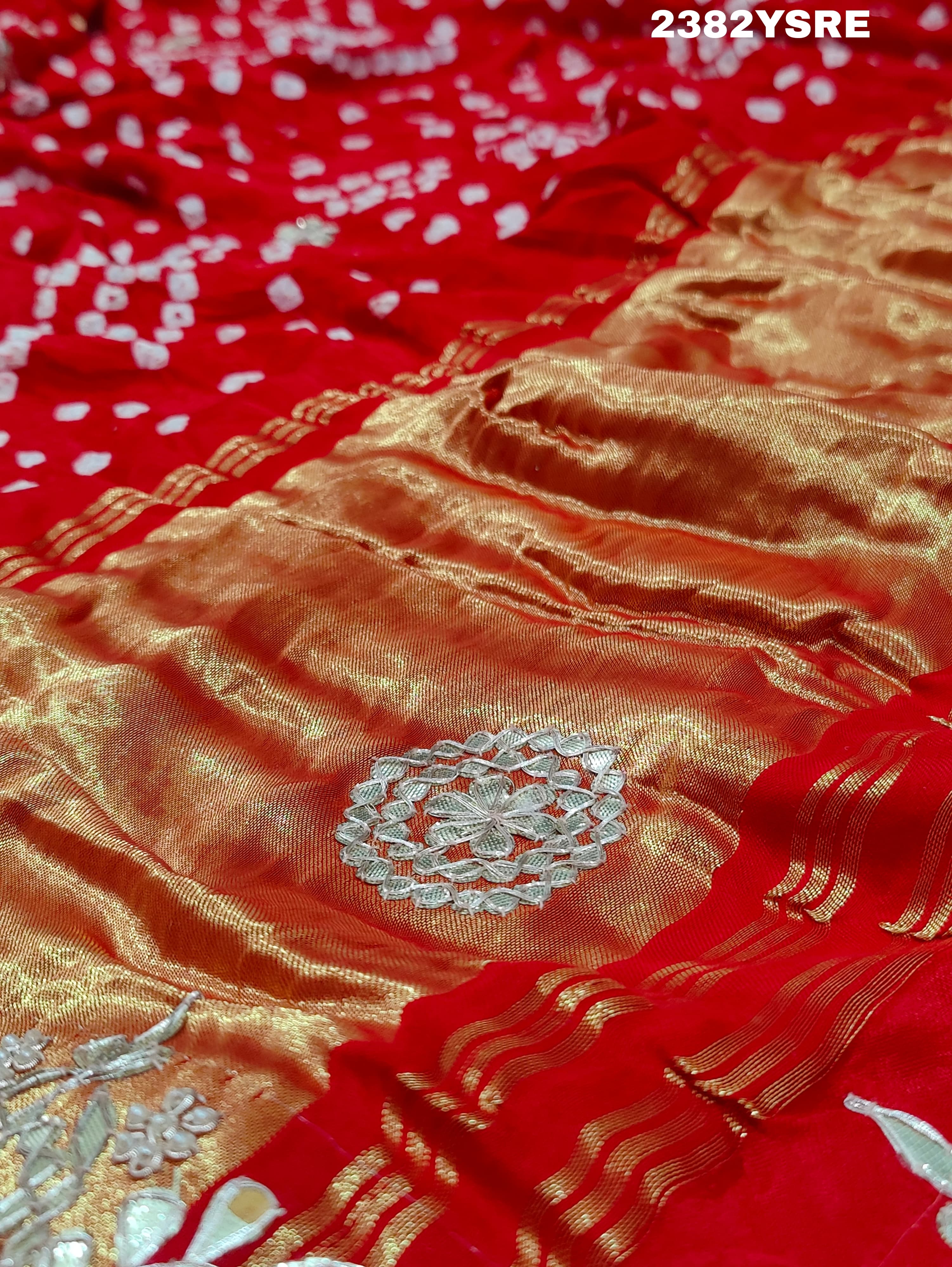 A red saree with white bandhani (dot) pattern and gotapatti border,