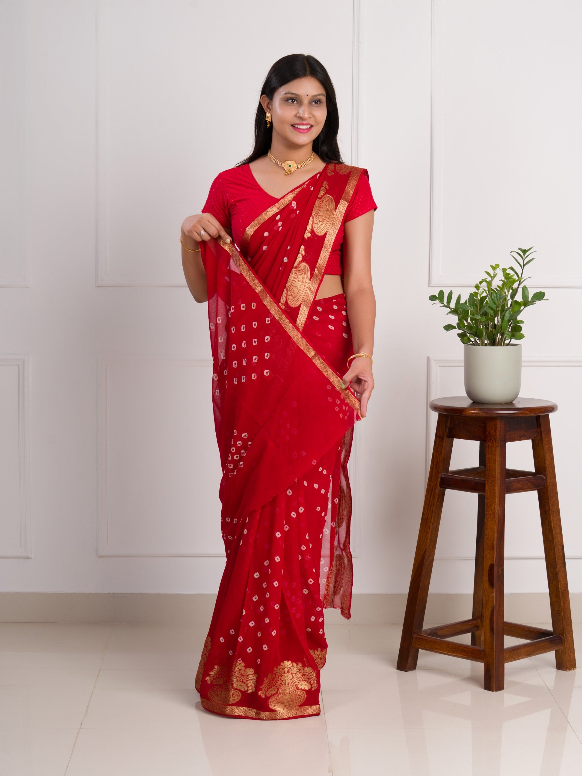 A red saree with gold patternsin Georgette Bandhani Style Saree