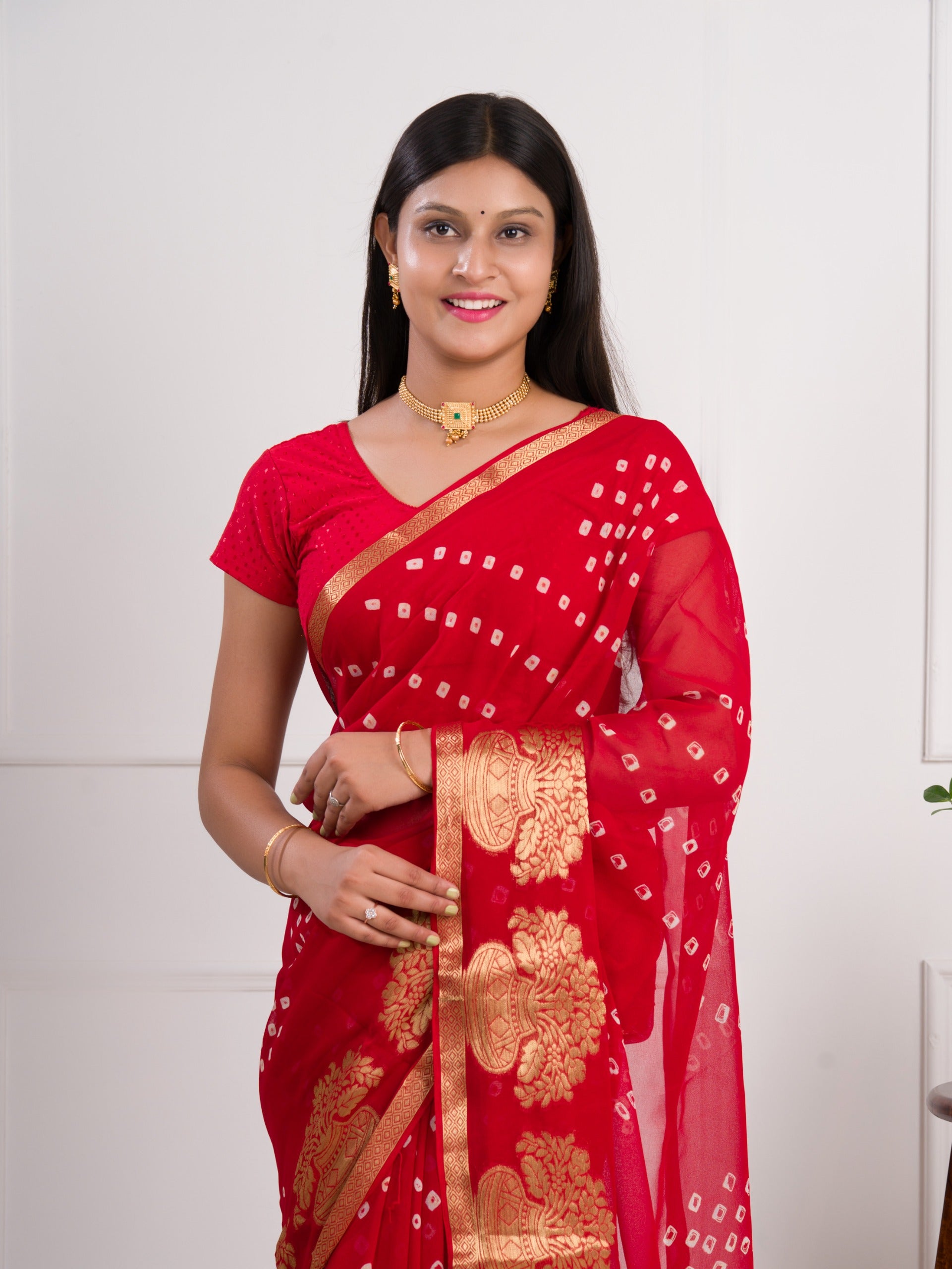 A red saree with gold patternsin Georgette Bandhani Style Saree