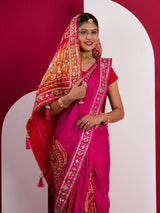 A pink saree with a red and gold border