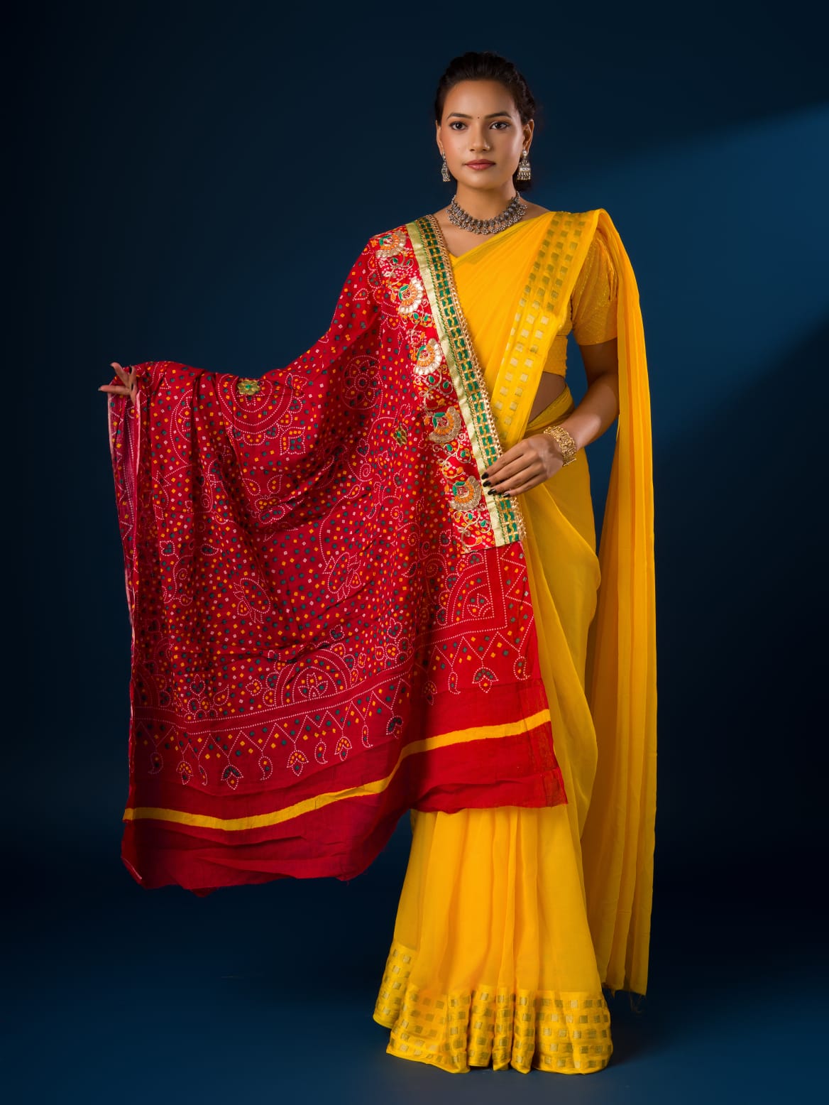 Ared and yellow traditional chunri dupatta with floral and geometric patterns and yellow embellishments.