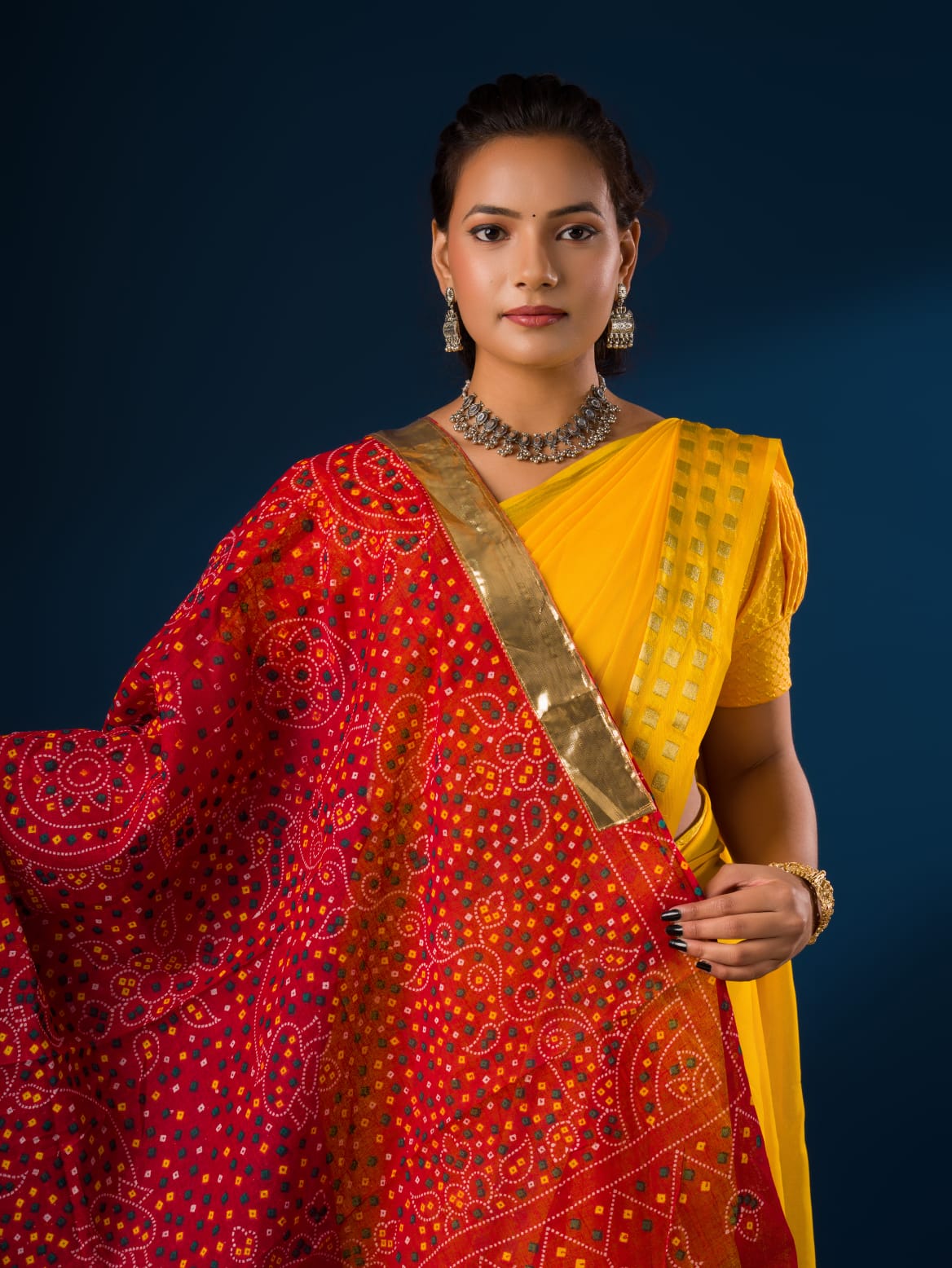 A woman wearing a traditional red and yellow dupatta with a geometric pattern