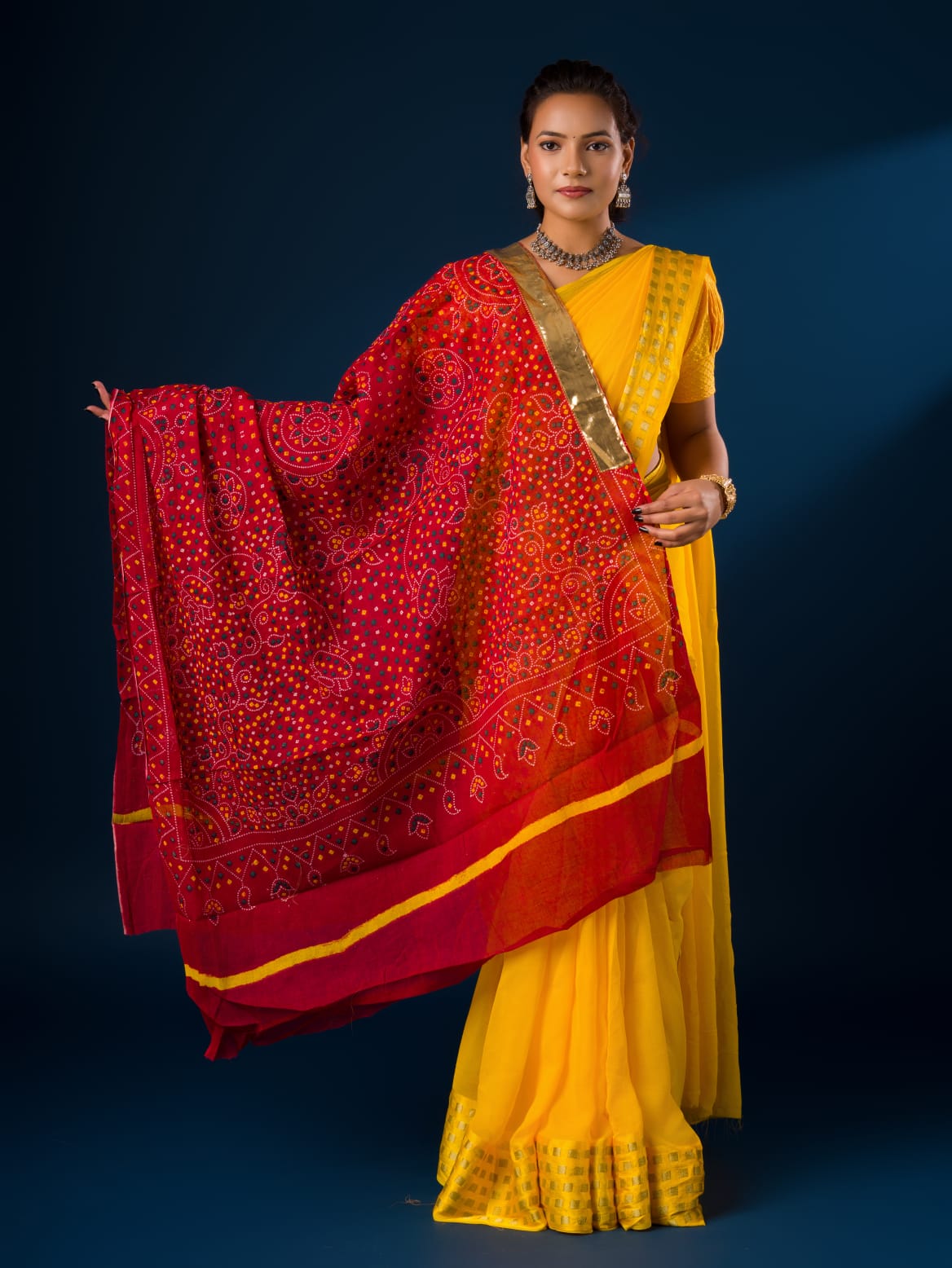 A woman wearing a traditional red and yellow dupatta with a geometric pattern