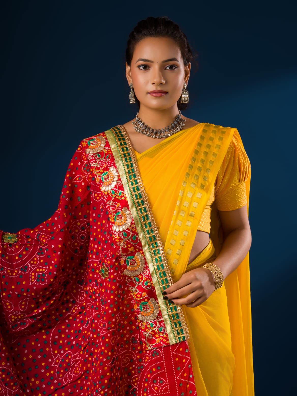 Ared and yellow traditional chunri dupatta with floral and geometric patterns and yellow embellishments.
