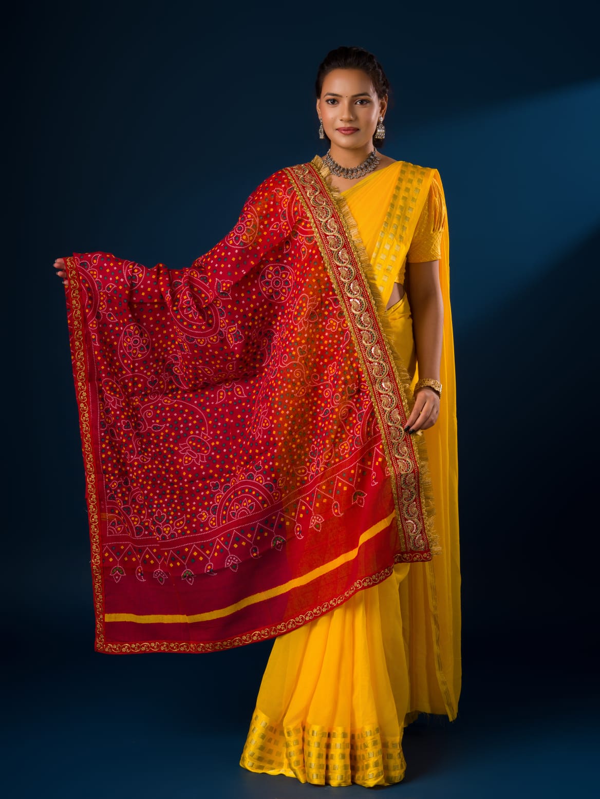A woman modeling a red and yellow traditional dupatta with embroidery border