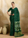 A bottle green saree with bandhani print and lagdi patola pallu, alongside a blouse piece.