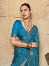 A blue chiffon georgette saree with bandhani print, featuring a sky blue color and decorative patterns, paired with a blue blouse.