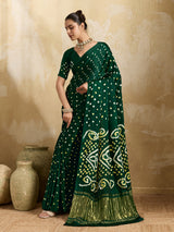 A bottle green saree with bandhani print and lagdi patola pallu, alongside a blouse piece.