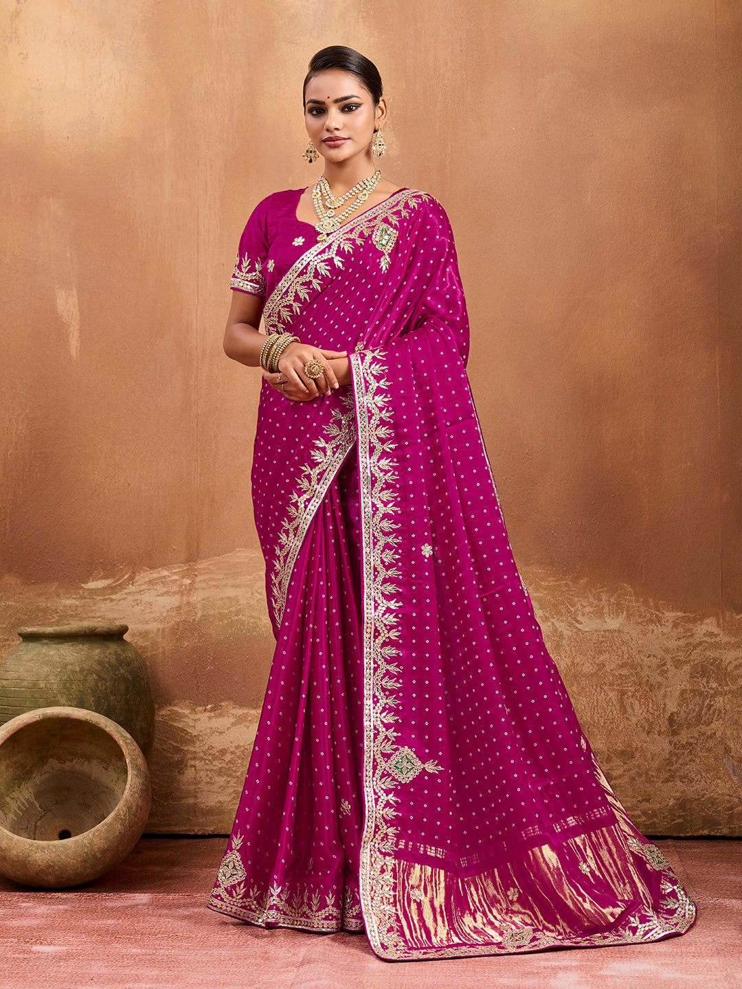 A pink modal silk saree with bandhani pattern and gotapatti work