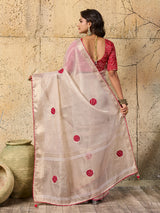 A white saree with red beads work and cutdana embellishments.