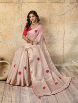 A white saree with red beads work and cutdana embellishments.