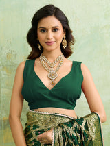 A bottle green Banarasi silk saree with heavy zari work and a gharchola pattern