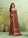  A maroon and gold Banarasi silk saree with heavy zari work (embroidery) and mirror handwork. The saree is traditional wear, likely used for festive or bridal occasions.