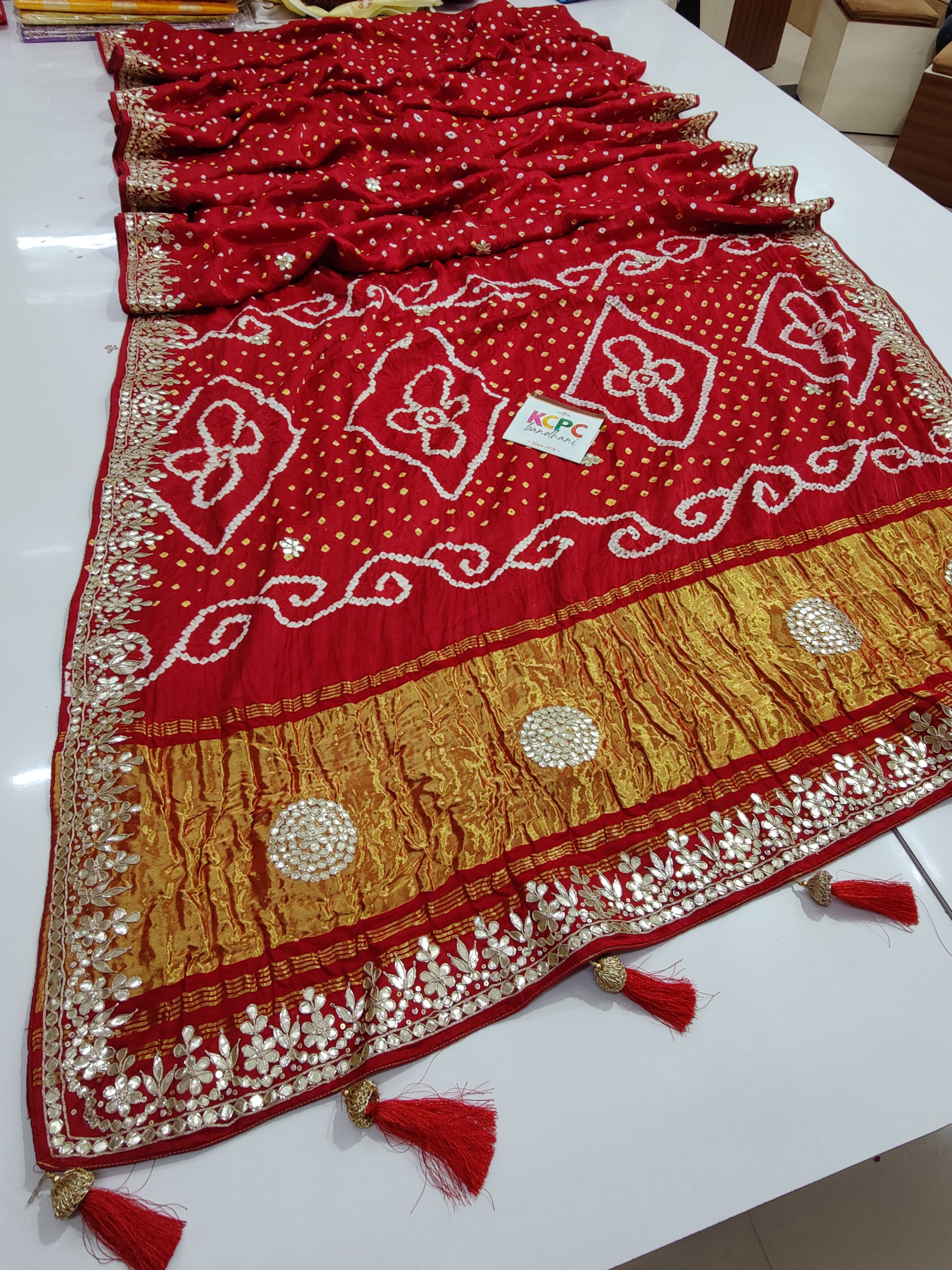 A red bandhani style sarees with gota patti embellishments