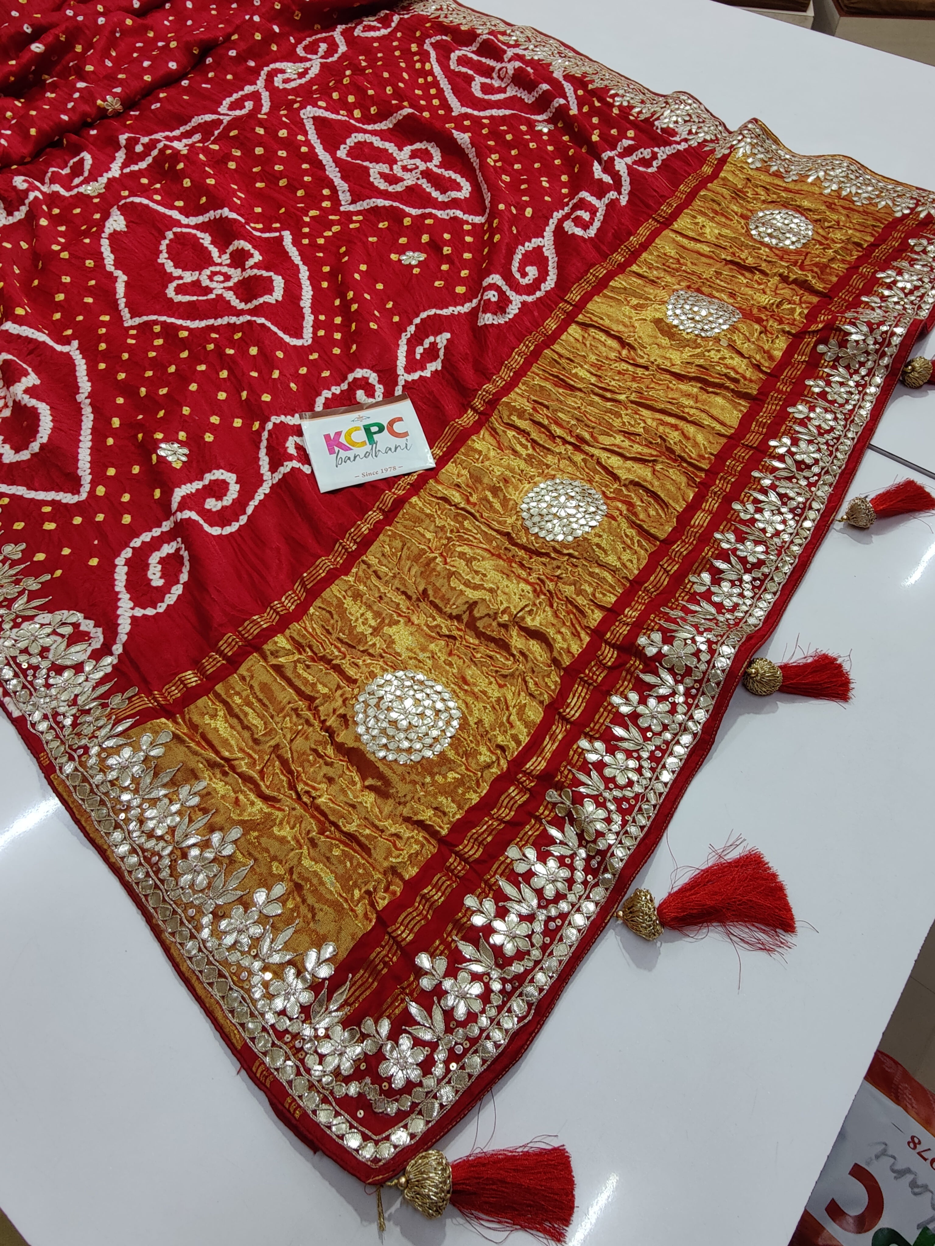 A red bandhani style sarees with gota patti embellishments